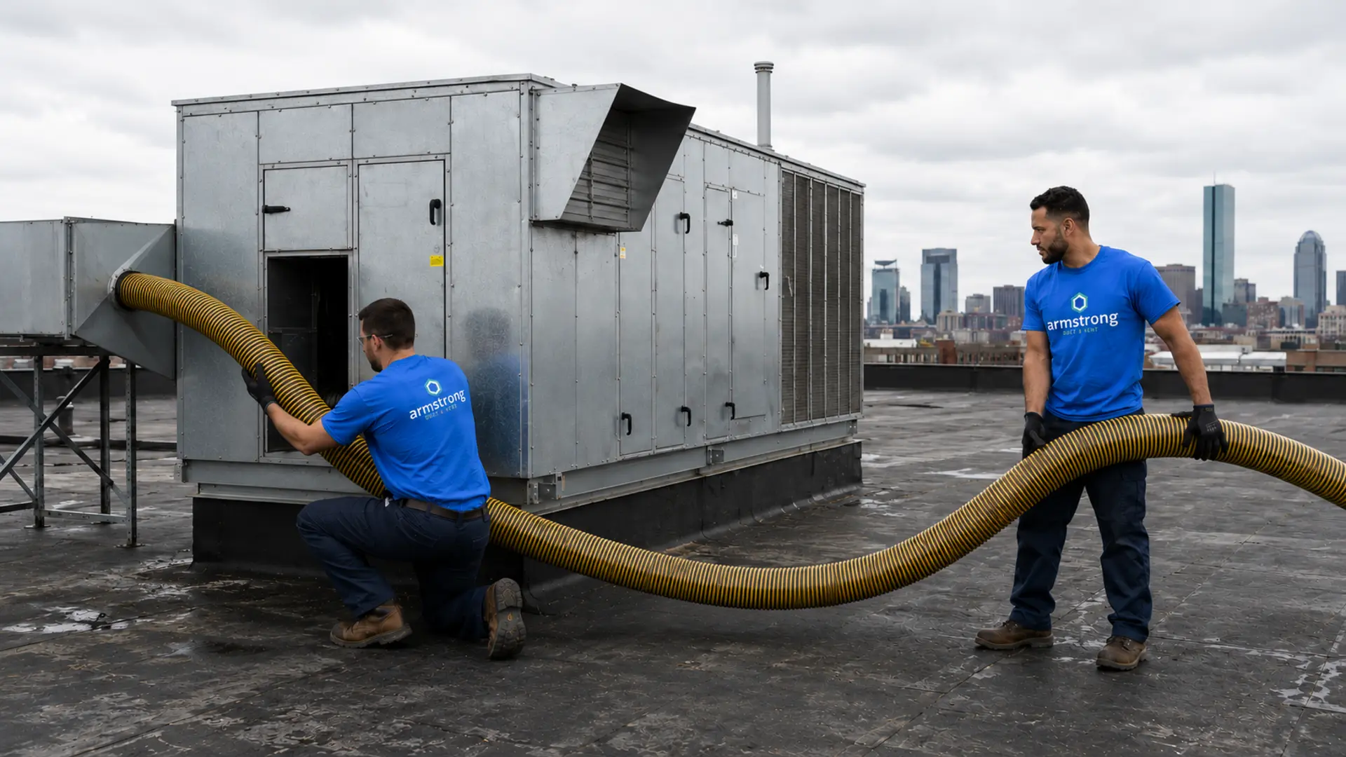 Armstrong technician cleaning a rooftop commercial exhaust duct fan on an industrial building